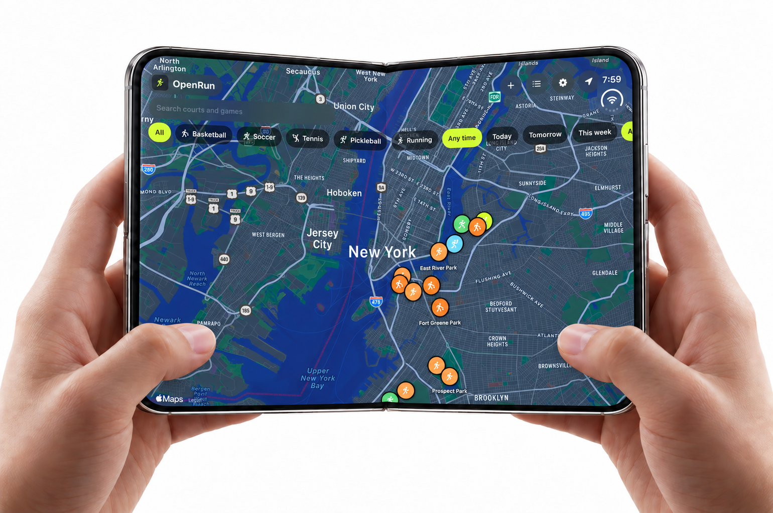 Two hands holding an open iPhone Duo that shows the OpenRun map of the New York area, with filters for Basketball, Soccer, Tennis, Pickleball and Running, and game pins around East River Park, Fort Greene Park and Prospect Park.